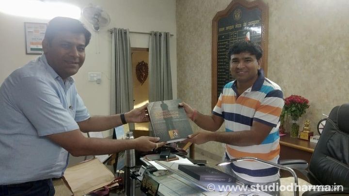 PRESENTING COFFE TABLE BOOK OF “STUDIODHARMA” TO THE DIVISIONAL COMMISSIONER OF MEERUT.